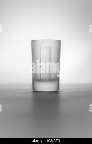 Ein smart und elegant erfassen ein Schnapsglas. Tolle Atmosphäre mit spot-Licht und Schatten. Es ist ein kleines Glas Alkohol. Stockfoto