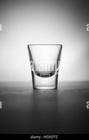 Ein smart und elegant erfassen ein Schnapsglas. Tolle Atmosphäre mit spot-Licht und Schatten. Es ist ein kleines Glas Alkohol. Stockfoto