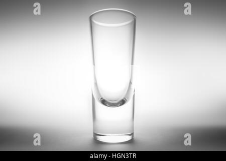 Ein smart und elegant erfassen ein Schnapsglas. Tolle Atmosphäre mit spot-Licht und Schatten. Es ist ein kleines Glas Alkohol. Stockfoto