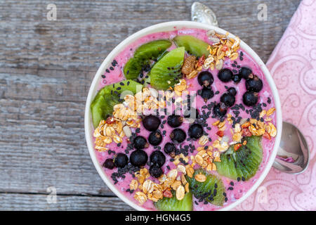 Smoothie-Schüssel mit Kiwi, Sesam, Müsli und Beeren. Liebe für eine gesunde Rohkost-Konzept. Stockfoto