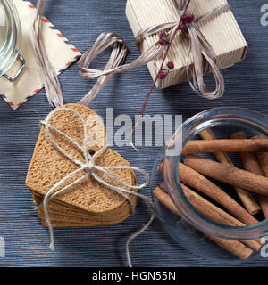 Geschenk zum Valentinstag. Herzform Lebkuchen, Umschlag und Geschenk verpackt in einer Schachtel aus Wellpappe für einen lieben Menschen. Stockfoto