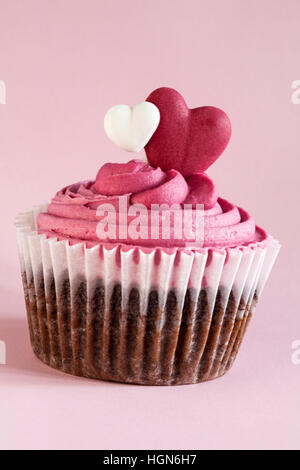 Marks & Spencer süsses Herz Cupcake isoliert auf rosa Hintergrund - ideal für Valentinstag, Valentinstag Stockfoto