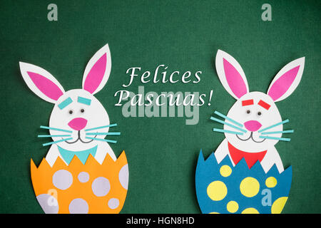 Lustige handgefertigte Comic Kaninchen in Eiern und Text in Spanisch "Felices Pascuas', was bedeutet"Frohe Ostern Urlaub"platziert. Stockfoto