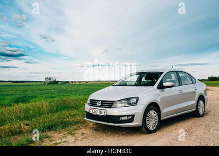 Gomel, Weißrussland - 13. Juni 2016: Volkswagen Polo Parkplätze am Straßenrand der Landstraße auf einem Hintergrund von Frühlingsgrün Felder oder Wiese Stockfoto