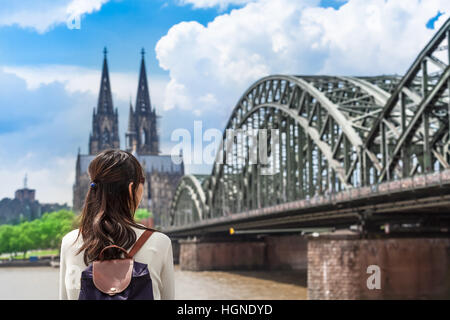 Junge Frau aus rückblickend Fluss Rhein gesehen, riesige Brücke und den berühmten Dom von Köln, Deutschland Stockfoto