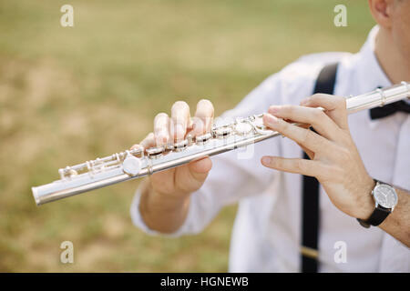 junger Mann eine Klarinette oder Querflöte zu spielen. Flötist Musiker Stockfoto