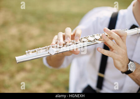 junger Mann eine Klarinette oder Querflöte zu spielen. Flötist Musiker Stockfoto