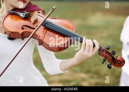 Geiger-Frau. Junge Frau spielt eine Geige vor. Stockfoto