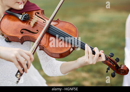 Geiger-Frau. Junge Frau spielt eine Geige vor. Stockfoto