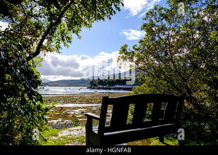 Bank im Hinblick auf die Coloful Gebäude auf den Hafen von Portree, die größte Stadt auf der Isle Of Skye in der Inneren Hebriden Scotland Stockfoto