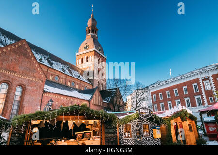 Riga, Lettland - 1. Dezember 2016: Weihnachtsmarkt auf dem Domplatz mit Rigaer Dom In Riga, Lettland. Handelshäuser mit Verkauf von Weihnachten G Stockfoto