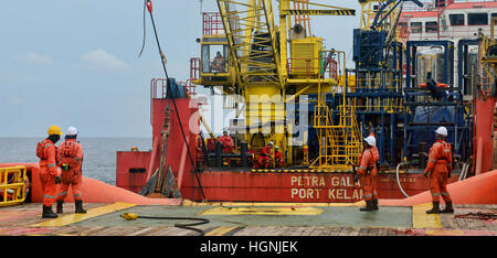 Schiff deck Hand warten, oder stehen an Deck zu erhalten Anker von der Arbeit Boot vor Anker ab Stockfoto