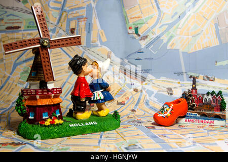 Holland Souvenir mit Amsterdam Karten im Hintergrund. Holländische Windmühle mit Küssen Kinder. Holländische Holzschuhe und Amsterdam Magnet. Stockfoto