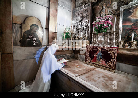 Jerusalem, Israel - 26. Juli 2014: Eine Nonne betet auf den Knien in der Edicula im Heilig-Grab-Kirche Stockfoto