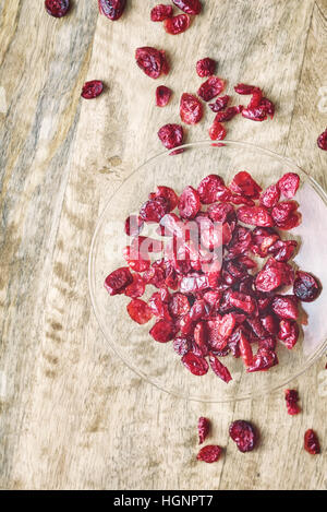 Getrocknete Cranberries in der Glasschüssel auf dem Holztisch Stockfoto