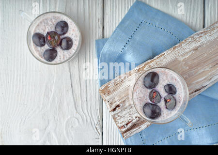 Chia Pudding mit Trauben auf der weißen hölzernen Tischplatte-Ansicht Stockfoto