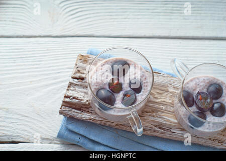 Chia Pudding mit Trauben auf dem horizontalen weißen Holztisch Stockfoto