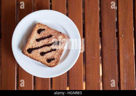 Nutella auf Toast in weiße Scheibe auf Holztisch Fensterlicht Stockfoto