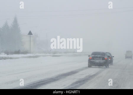 Bukarest, Rumänien, 25. Januar 2016: Autos werden auf einer verschneiten Straße in einem Schneesturm in Bukarest bestanden. Stockfoto