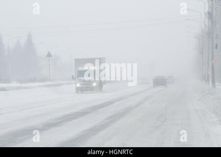 Bukarest, Rumänien, 25. Januar 2016: Autos werden auf einer verschneiten Straße in einem Schneesturm in Bukarest bestanden. Stockfoto