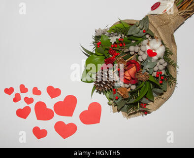Rote Herzen aus Papier und Blumenstrauß auf weißem Hintergrund Stockfoto
