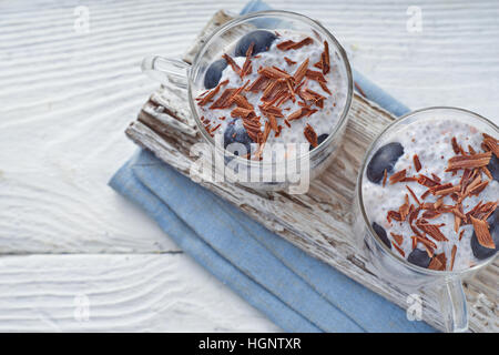 Chia Pudding mit Trauben und Schokolade Flocken auf dem horizontalen weißen Holztisch Stockfoto