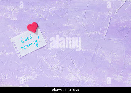 Blatt-Notebook Inschrift guten Morgen auf lila Tischplatte. Das gemütliche Frühstück oder zum Muttertag. Kopieren Sie Raum. Stockfoto