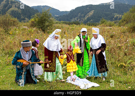Kasachische Frauen zeigen lokale Tradition von Tusau Kesu, die eine Zeremonie symbolisiert, die die ersten Schritte eines Kindes begleitet, in Almaty, Kasachstan Stockfoto