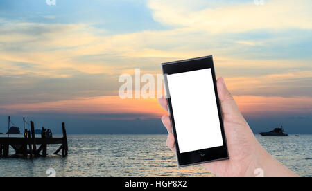 Hände halten Smartphone mit bunten Himmel in der Dämmerung Zeit Hintergrund Stockfoto