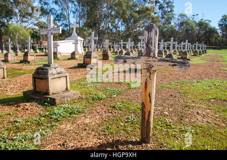 Verwitterte Kreuz, mit Reihen von Grabsteinen und cross-Marker mit großen Grab auf dem Friedhof in New Norcia, Western Australia Stockfoto