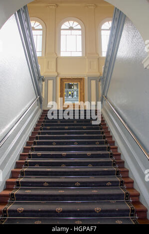 Innenraum mit Teppichboden ausgelegte Treppe mit Geländer in absteigender Perspektive im Hotel New Norcia in New Norcia, Western Australia. Stockfoto