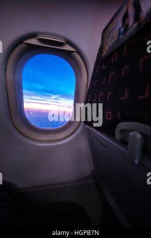 Blick auf einen Sonnenaufgang durch das Fenster eines Flugzeugs, ein easyJet Airbus A320 über Europa. Sitz der Fluggesellschaft. Fenster „EasyJet-Ebene“ Stockfoto