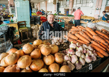 Batumi, Georgien - 28. Mai 2016: Die Reifen gedrungen georgischen Mann, sitzt der Händler Gemüse an der Theke Markthalle Bazar. Stockfoto