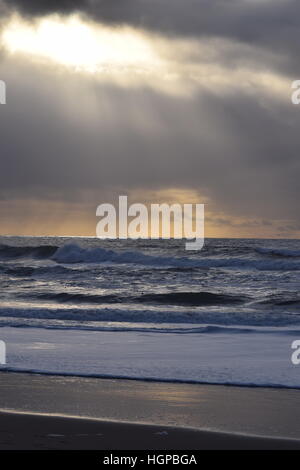 Sonne lugt durch die Wolken über dem Meer vor dem Sturm Stockfoto