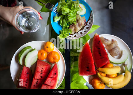 Platte mit Wassermelonen, Bananen, Orangen und Salat im Restaurant in Thailand Stockfoto