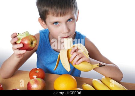 Fröhlicher Junge gesunde Ernährung Banane und Apfel isoliert weiß Stockfoto