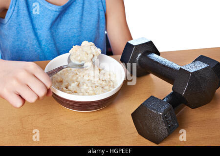 Junge essen Brei und Hanteln als Symbole der Sport lifestyle Stockfoto