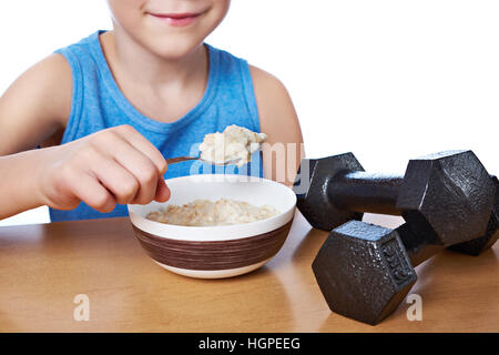 Junge essen Brei und Hanteln als Symbole der Sport lifestyle Stockfoto