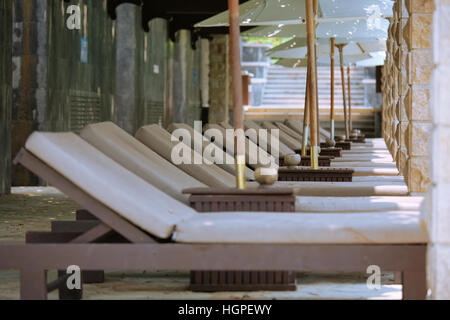 Reihe von Sonnenliegen und Sonne Schirme unweit der Swimmingpool des Hotels Stockfoto