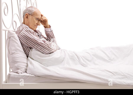 Besorgt Senior im Bett isoliert auf weißem Hintergrund Stockfoto
