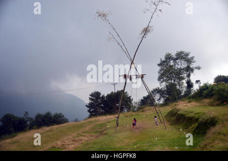 Kinder schwingen auf einem traditionellen Bambus (Dashain) Swing im Dorf Kande, Annapurna Sanctuary, Himalaya, Nepal, Asien. Stockfoto