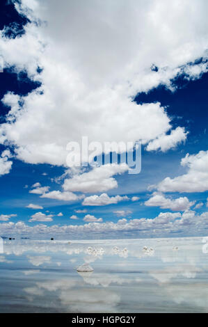 Tiefblauer Himmel mit langen weißen Wolken Spiegelbild im Wasser Uyuni Salt Flats Bolivien Stockfoto