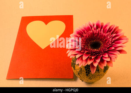 Karte mit Gerbera Blume in einer schmalen Vase für Glückwünsche mit hellen leeren Hintergrund Stockfoto