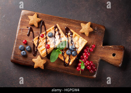 Waffeln und Beeren auf Holzbrett. Ansicht von oben Stockfoto