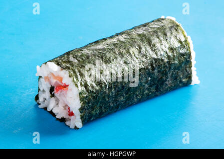 Nahaufnahme von unbeschnittenen Futomaki Sushi-Rolle in Nori auf blauen Oberfläche Stockfoto