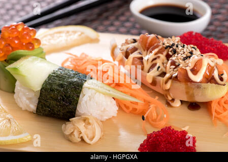 Japanische Küche Sushi set mit Lachs Fisch, serviert mit Sauce Tartar auf Holzbrett, Nahaufnahme Stockfoto