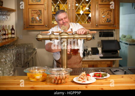 Barkeeper Gießen Bier vom Fass Stockfoto