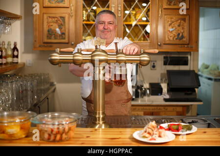 Barkeeper Gießen Bier vom Fass Stockfoto