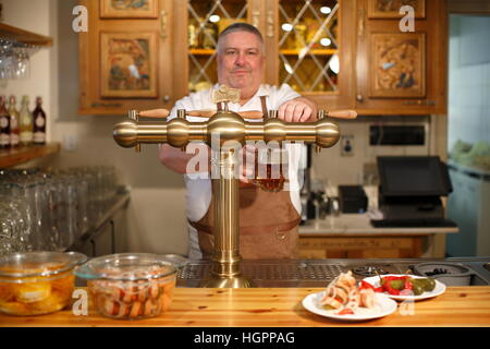 Barkeeper Gießen Bier vom Fass Stockfoto