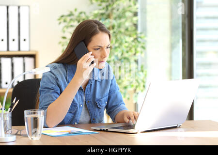 Selbständiger anrufenden Kunden-Support versucht, einen Fehler in Zeile mit einem Laptop in einem Desktop im Büro zu lösen Stockfoto